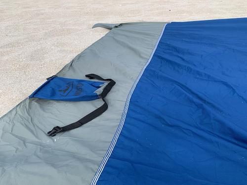 Dark blue SandStop blanket on sand with its pouch